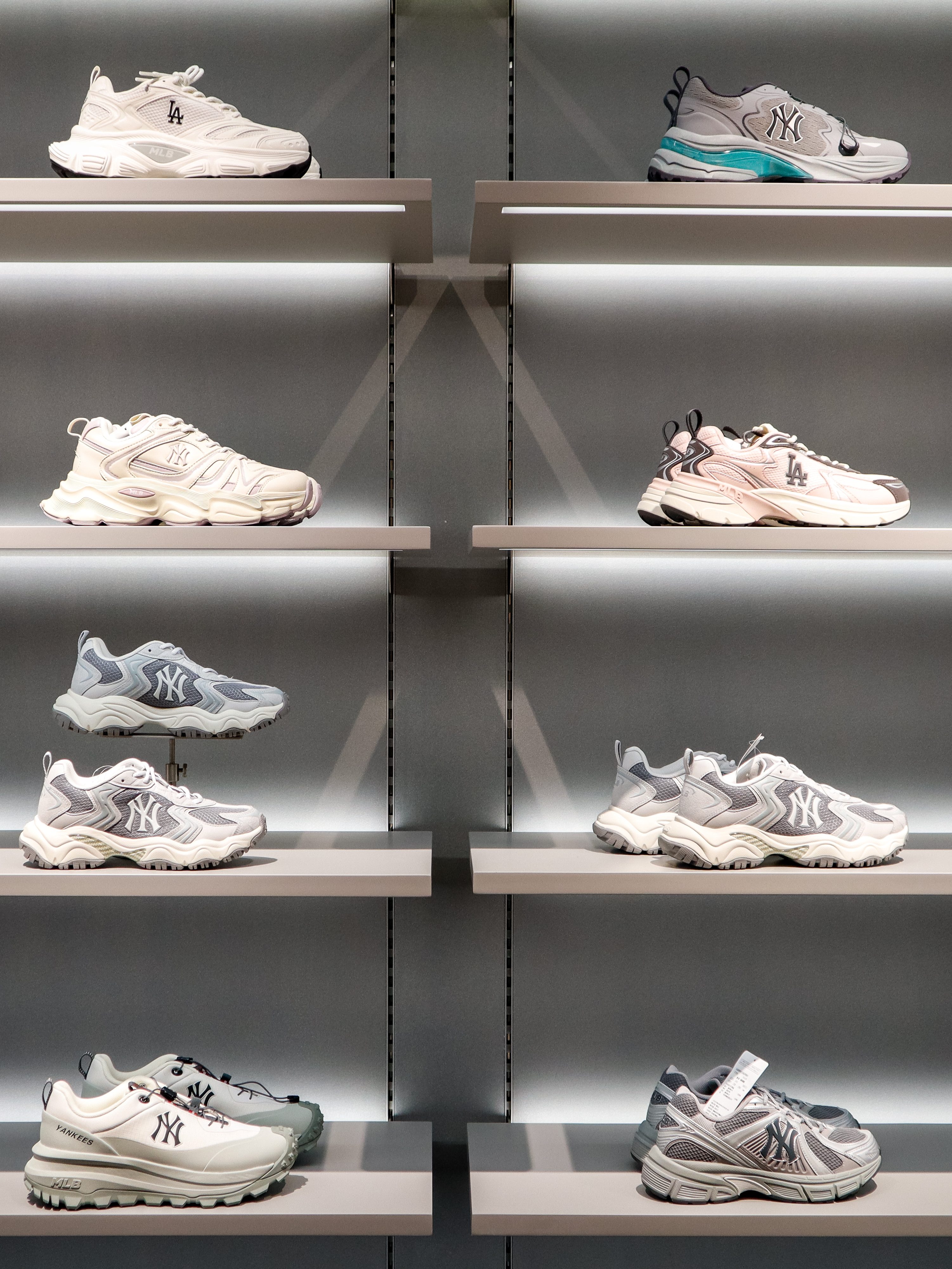 A display of various New York Yankees-themed sneakers arranged on store shelves, showcasing a range of styles and colors.
