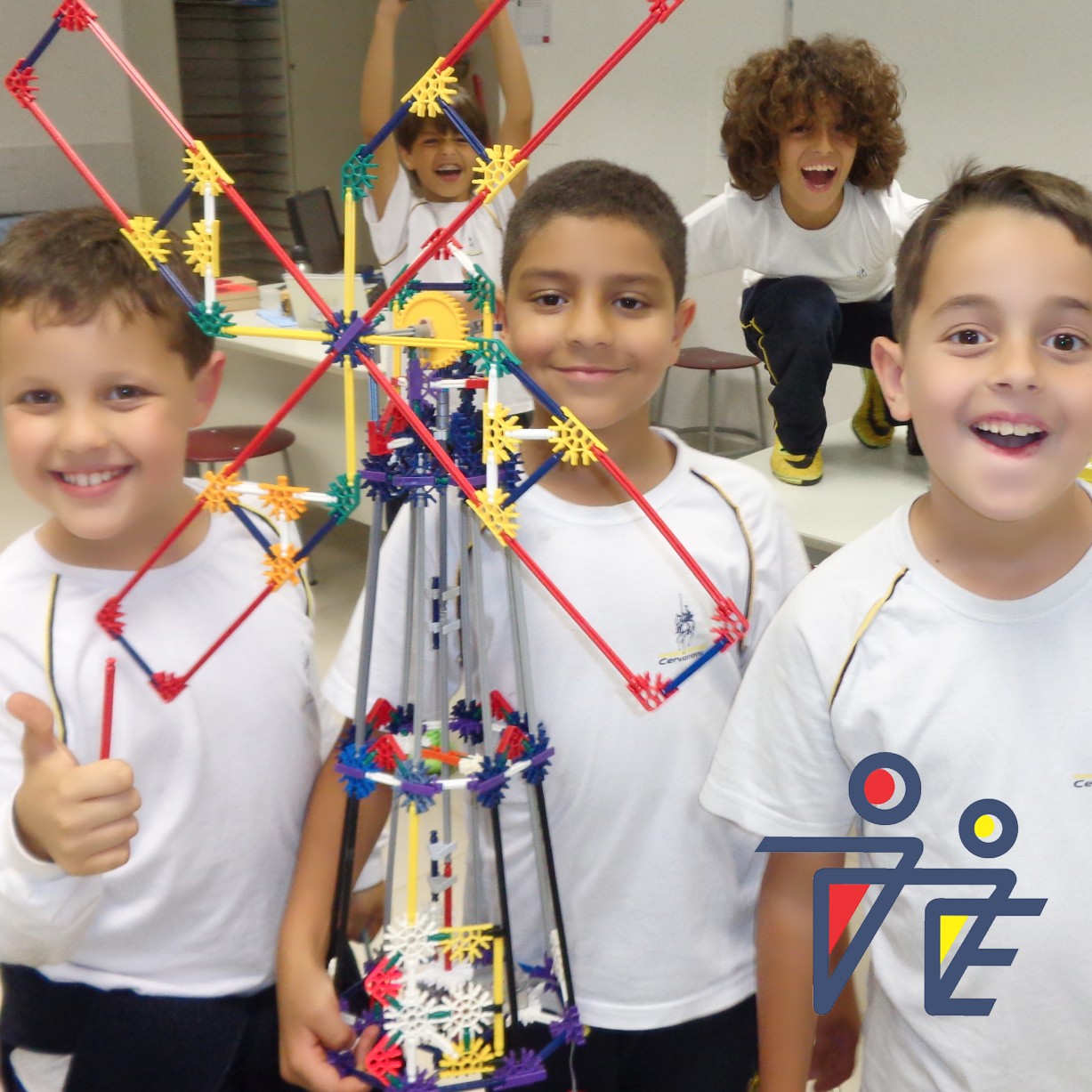 Crianças sorrindo com um Moinho de vento feito de peças coloridas