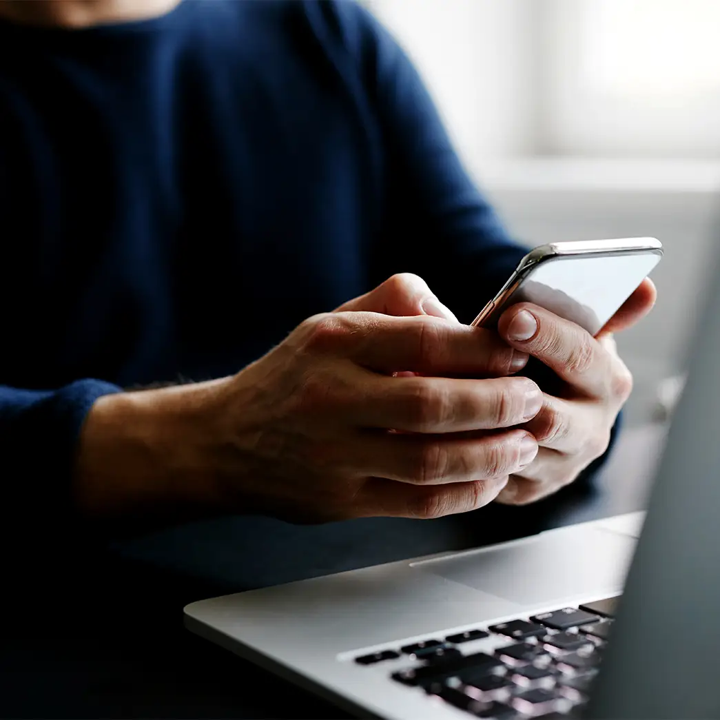 Customer reviewing insurance claim details on a mobile device during vehicle repair process.