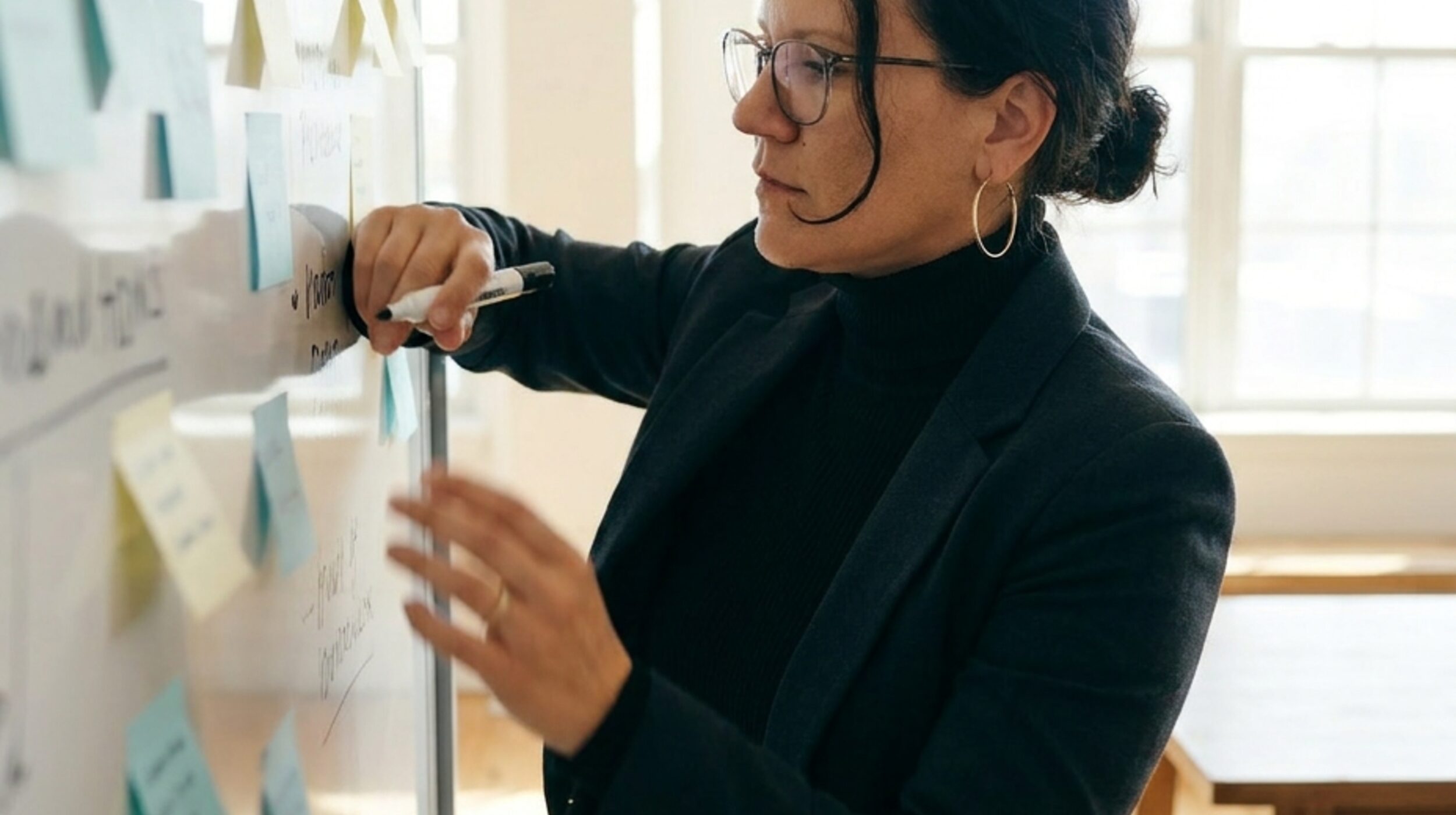 Sophie Kalkum von Studio Alma schreibt auf Whiteboard