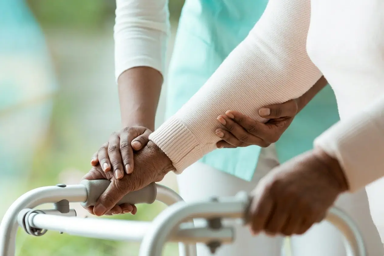 Healthcare professional assisting a patient with mobility and rehabilitation support