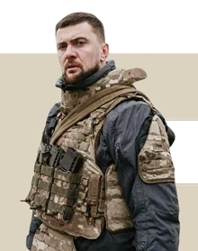 Військовий у формі ЗСУ впевнено стоїть і дивиться в кадр.