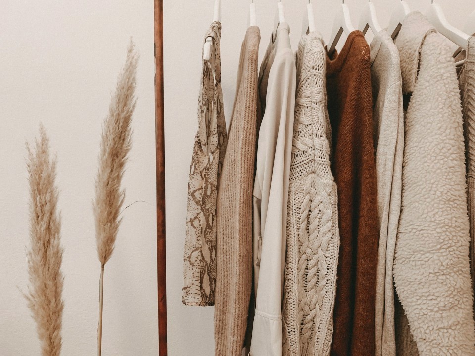 Sustainable organic cotton clothing hanging on a rack, representing transparent supply chain practices