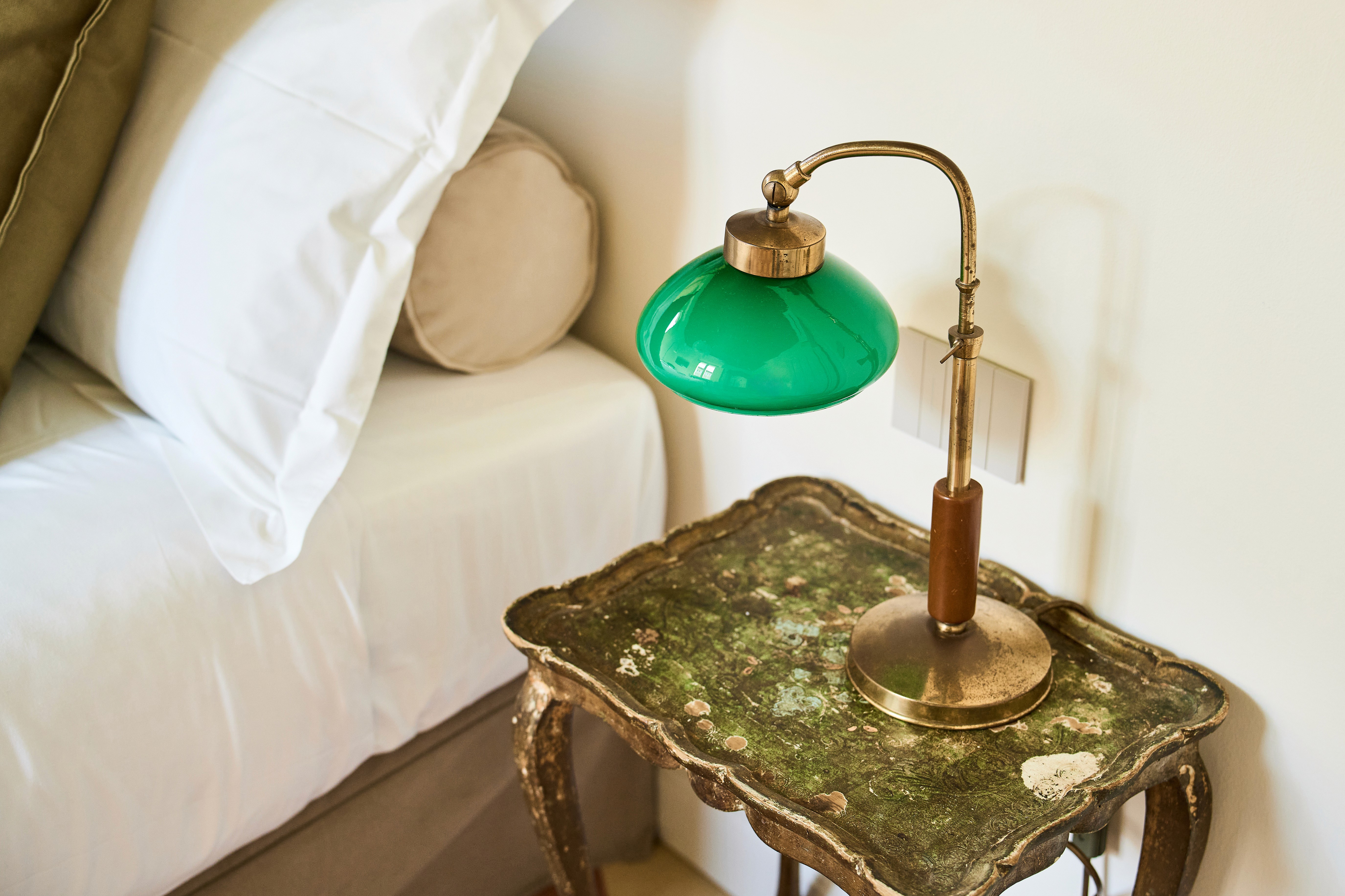 A woman with a radiant complexion lying down with a golden facial mask applied to her skin. She is wrapped in a warm orange towel, with sunlight casting a soft glow on her face, creating a relaxing and rejuvenating spa atmosphere.