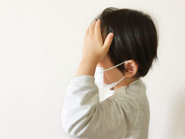 頭を抑えている子供