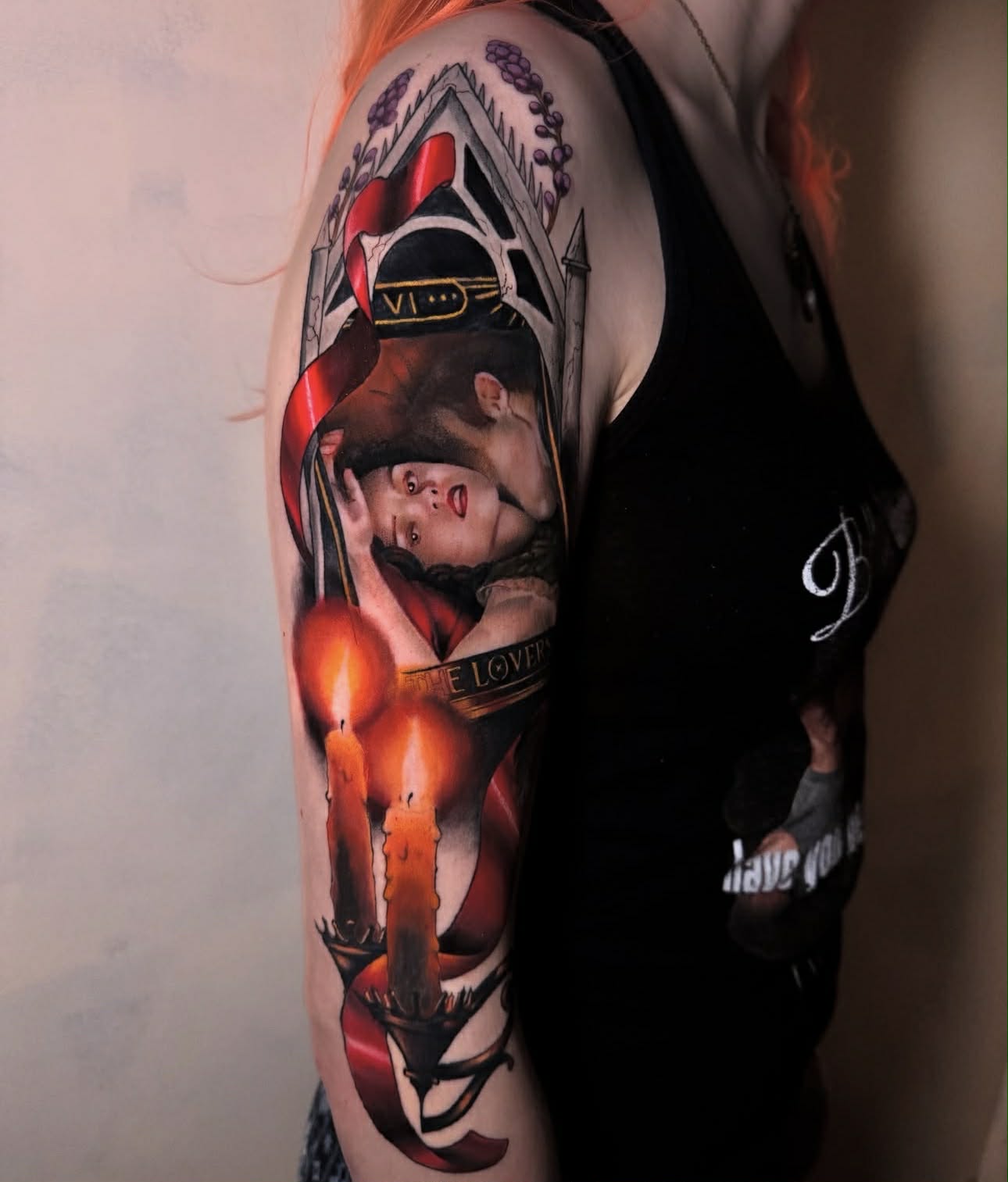 Realistic arm tattoo of broken mask, heart, and red accents.