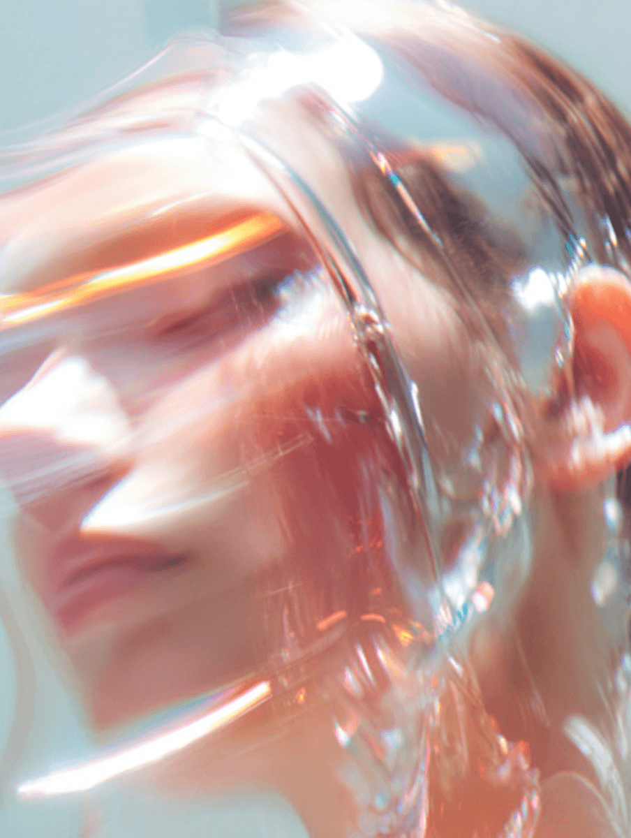 Abstract close-up portrait of a person with soft pastel tones, light reflections, and motion blur creating a dreamy, liquid-like visual effect.
