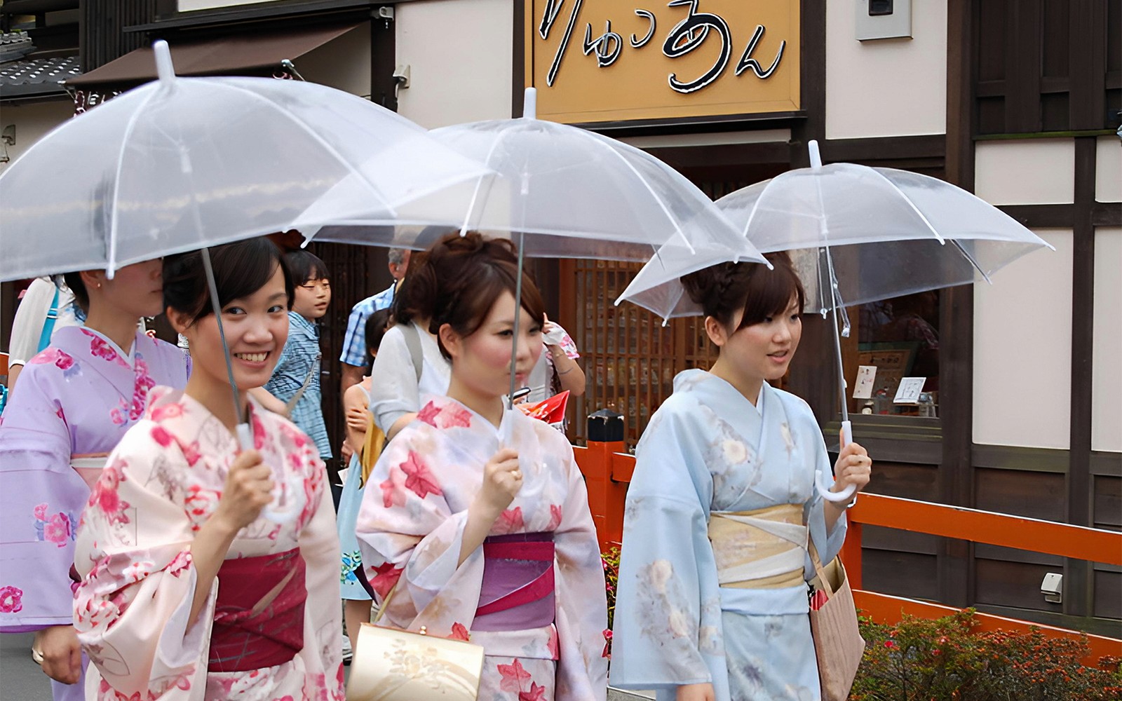 Woman in traditional kimono walking through Asakusa, Tokyo, with Senso-ji Temple in the background.