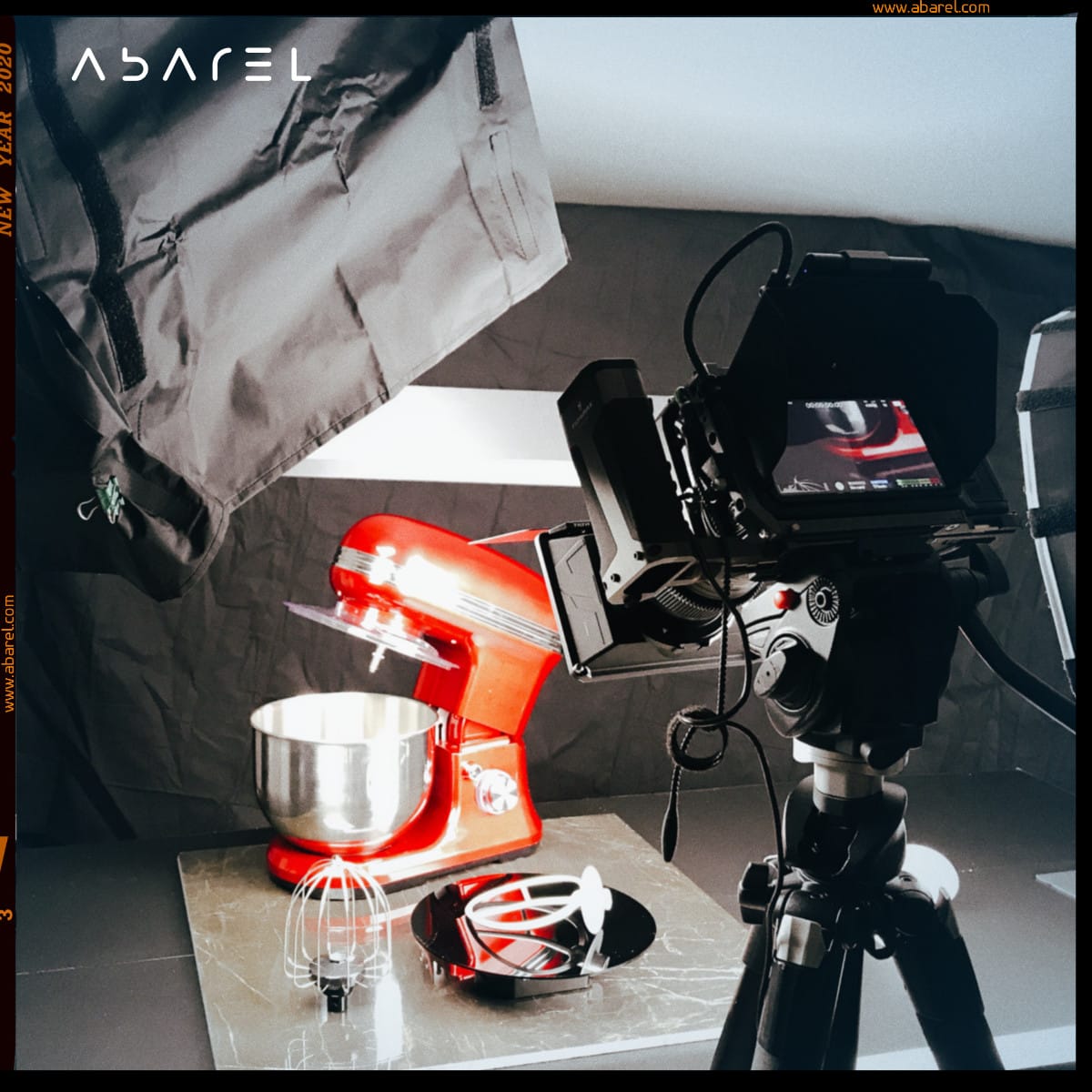 A person's hands serve a bowl of Vietnamese pho, featuring rice noodles, sliced beef, fresh herbs, lime wedges, sliced red chilies, and mushrooms, on a rustic wooden table.