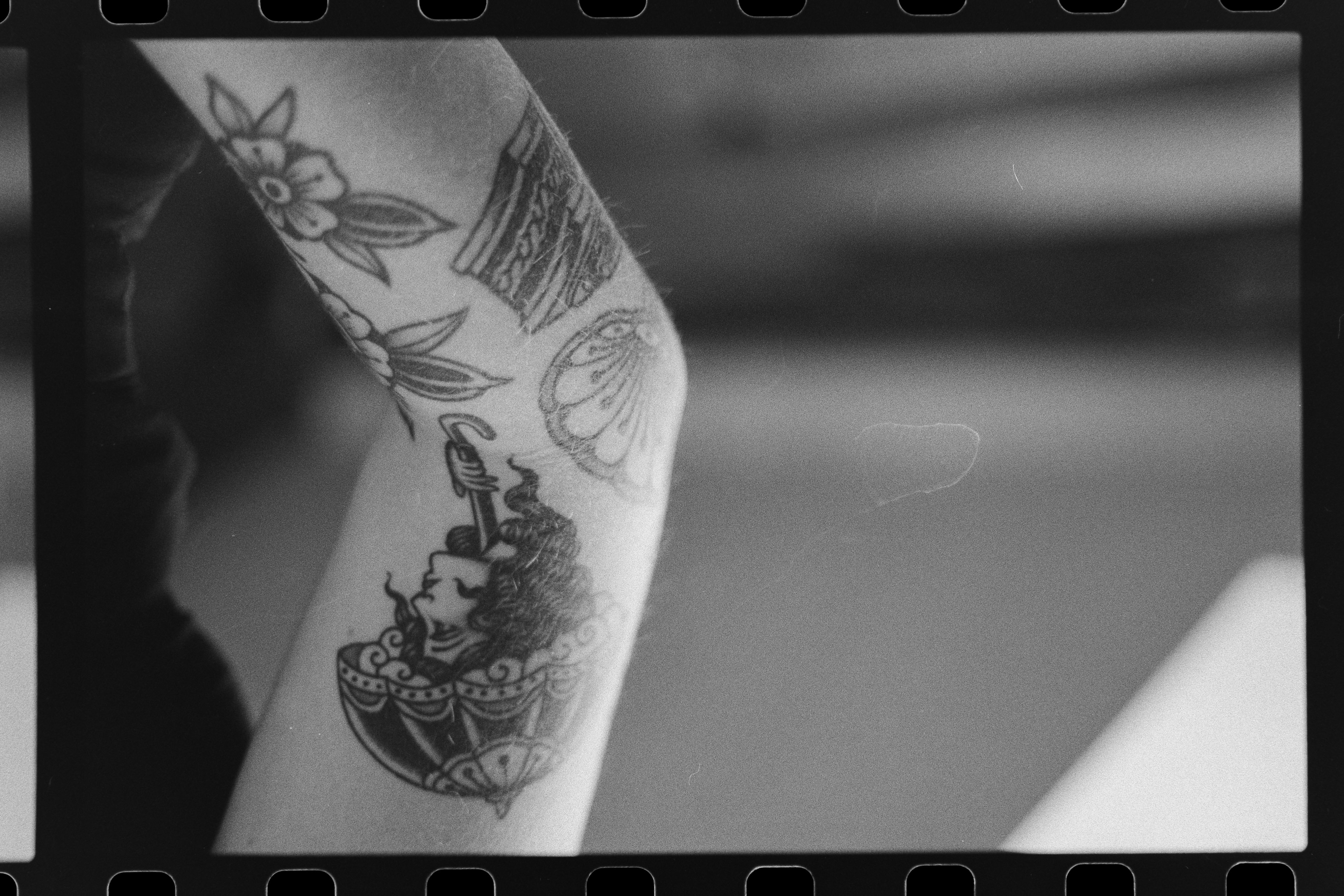 A close-up of a hand wearing multiple decorative rings against a blue background.
