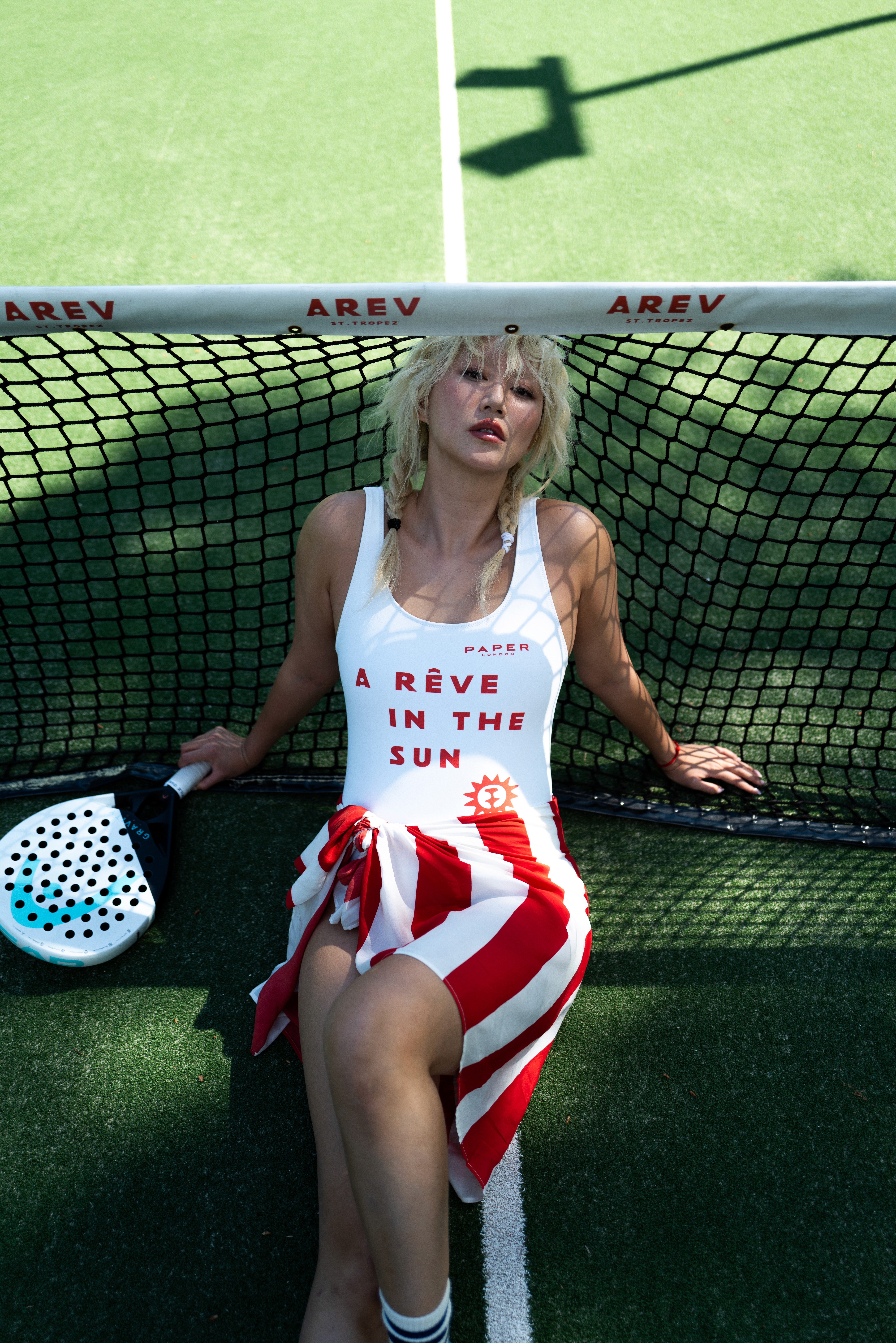Bride in white dress walking on street, man in background