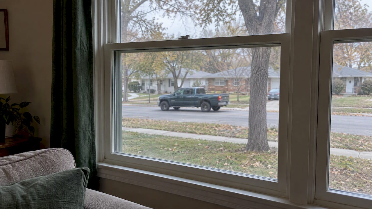 Closed home window overlooking neighborhood traffic