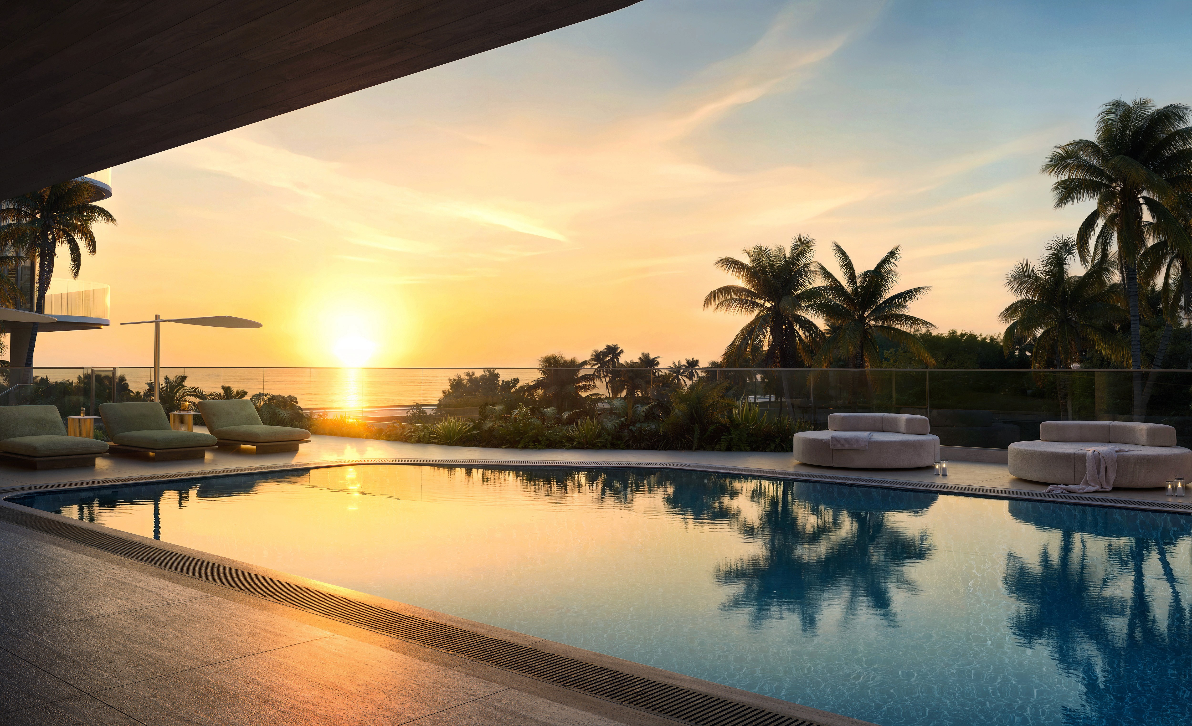 Infinity pool deck at Hollywood Moon: new condos in Hollywood FL surrounded by palm trees and sunset ocean views.