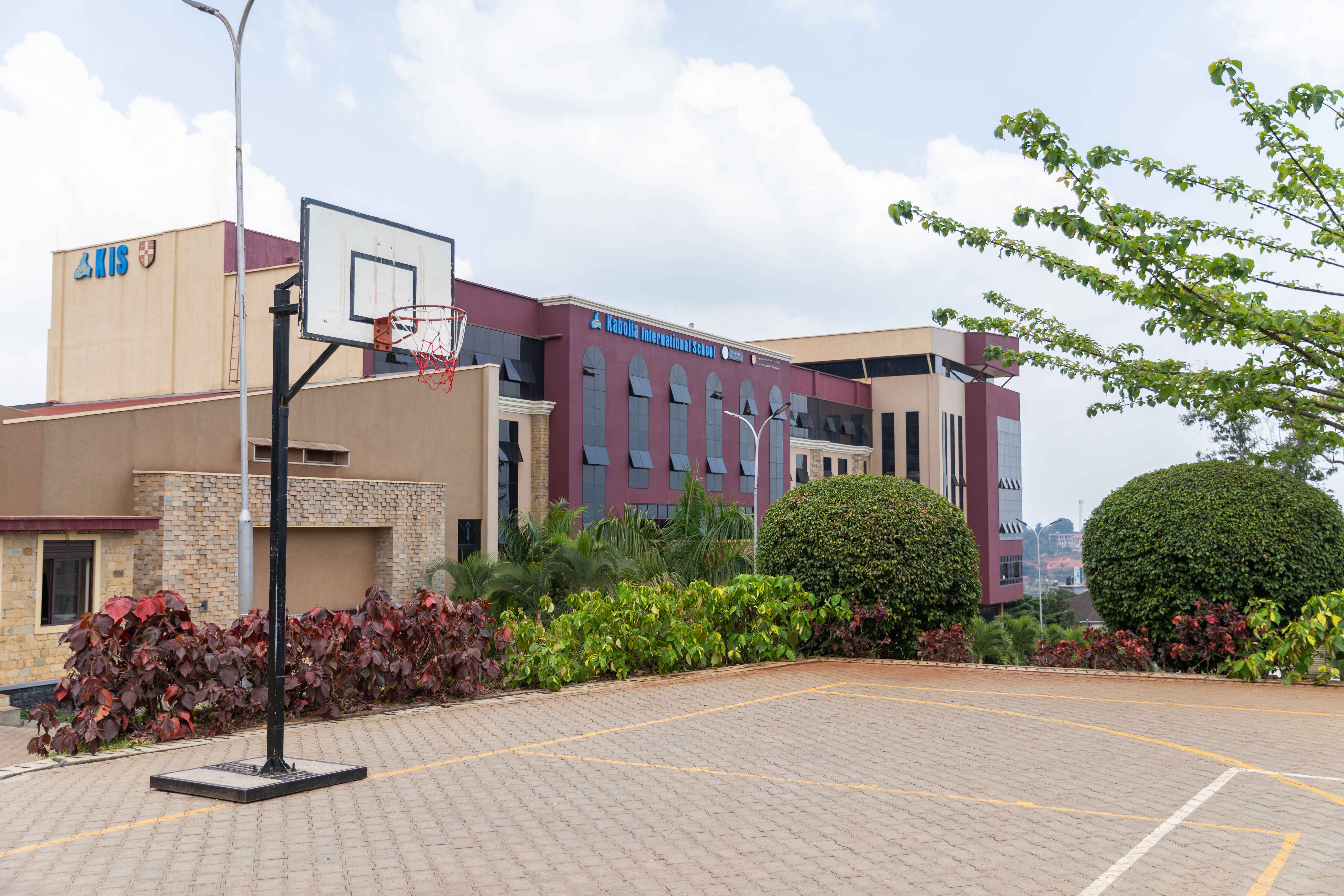 Two cheerful students are balancing books on their heads, smiling and laughing