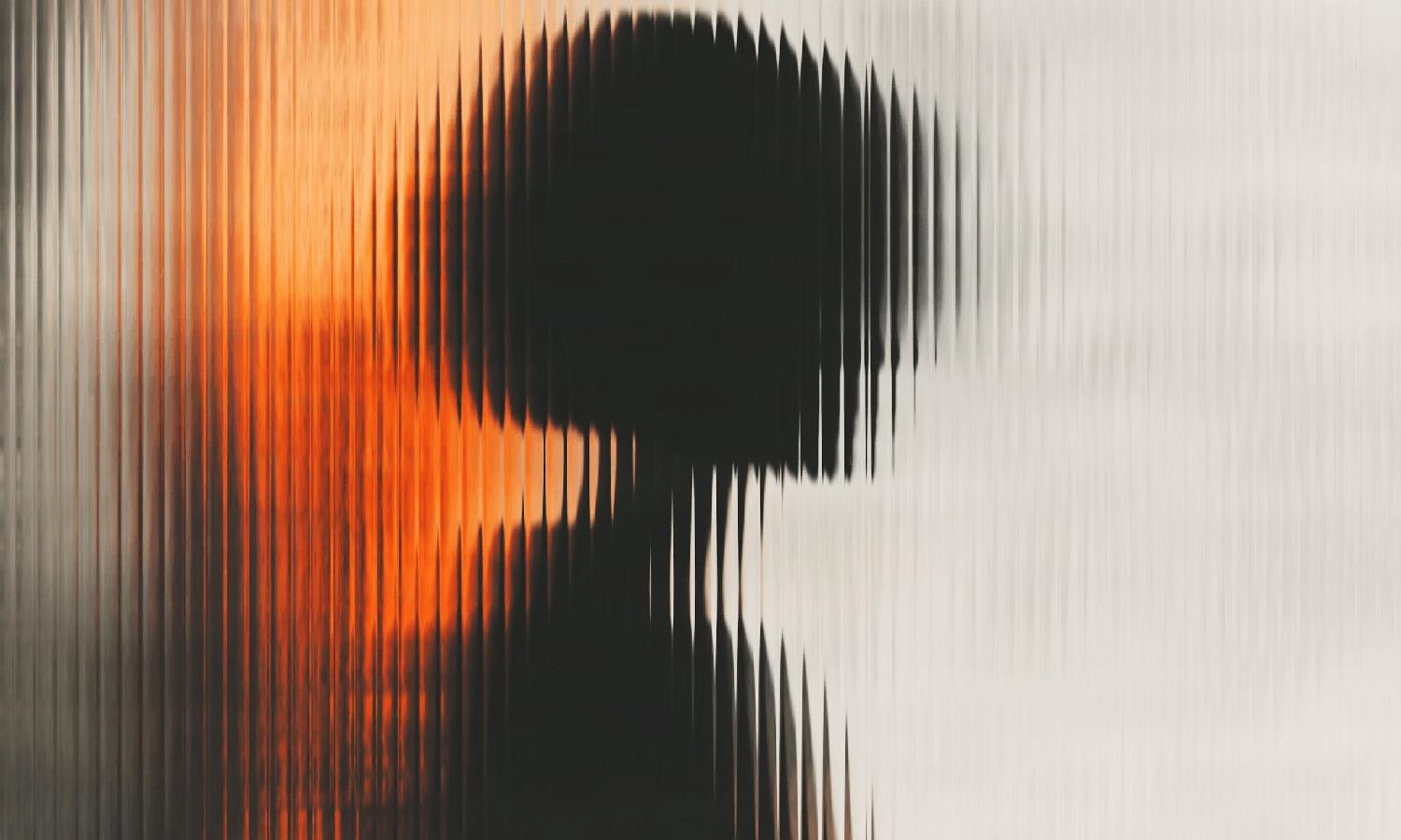 An abstract image showing a distorted dark silhouette of a person viewed through a vertically ribbed translucent surface, with wave-like patterns, warm orange and beige tones, and repeated “Unsplash+” watermark text across the image.
