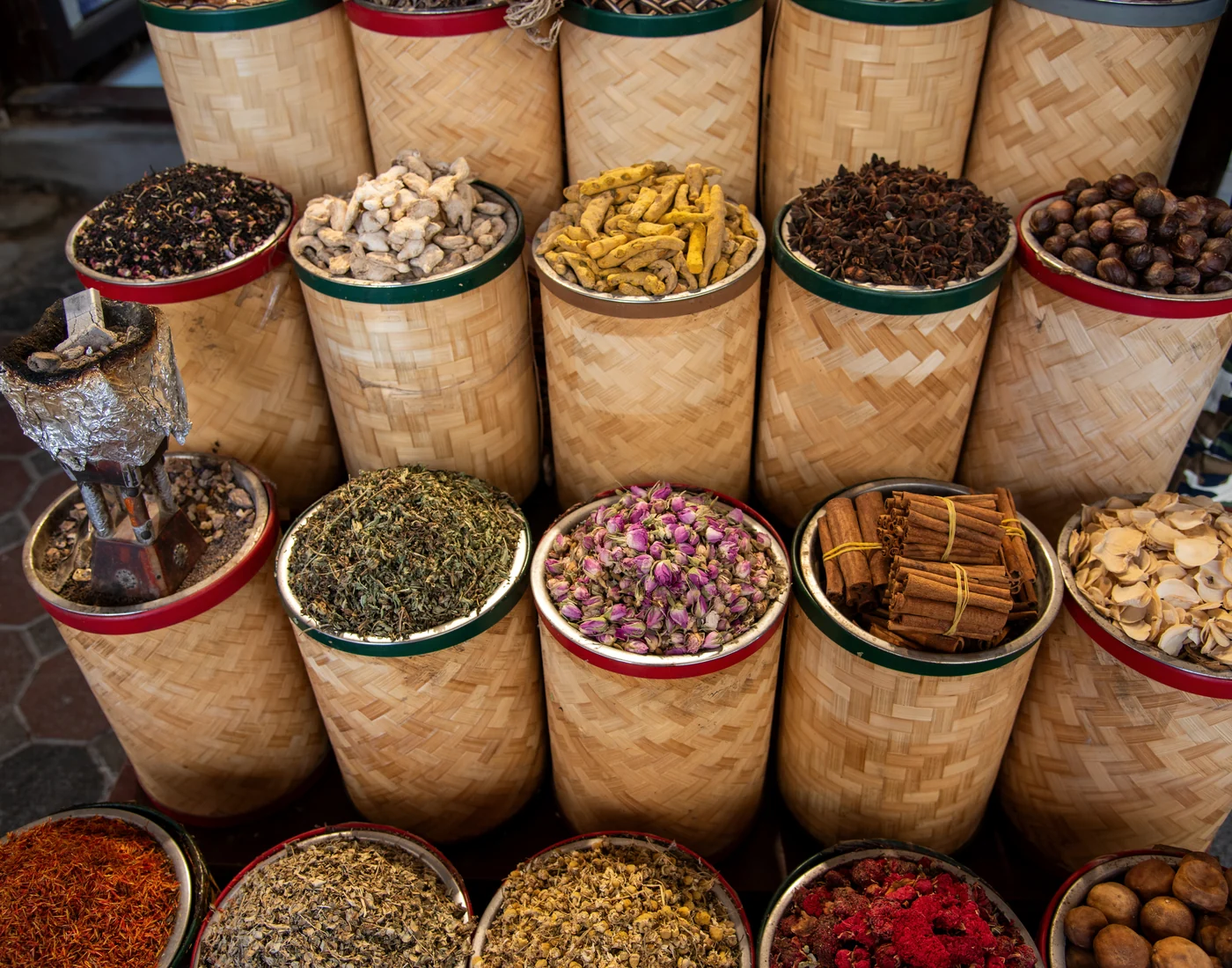Spice market with rosebuds, turmeric, cinnamon, herbs and woven baskets