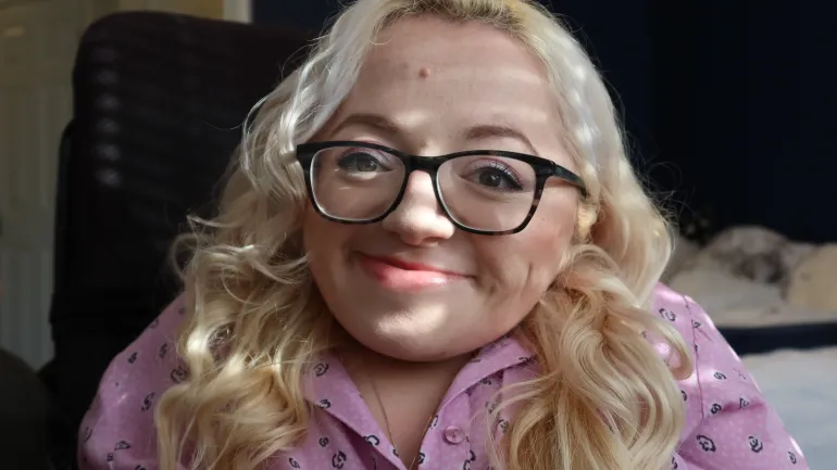 Gem smiling at the camera with pink shirt dress on