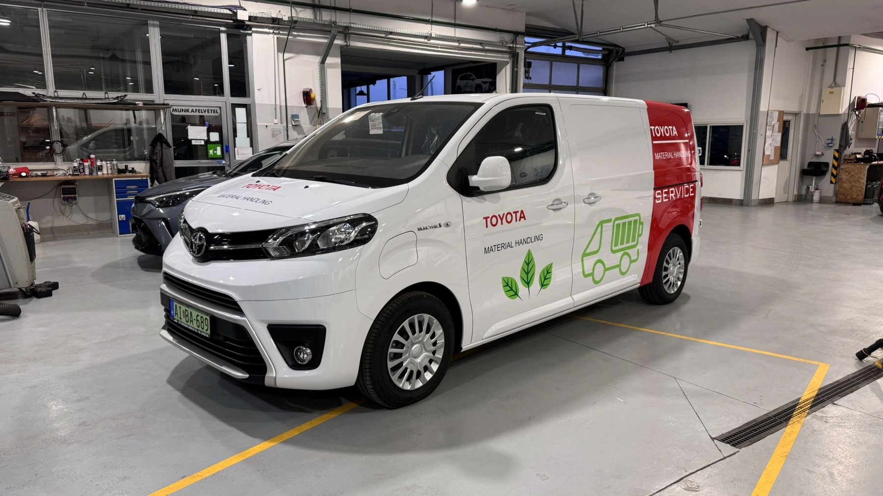 Toyota Material Handling elektromos furgon egyedi, gyári minőségű flottadekorációja. Letisztult, környezettudatos céges autófóliázás és márkaépítés a Nortek stúdiójában.