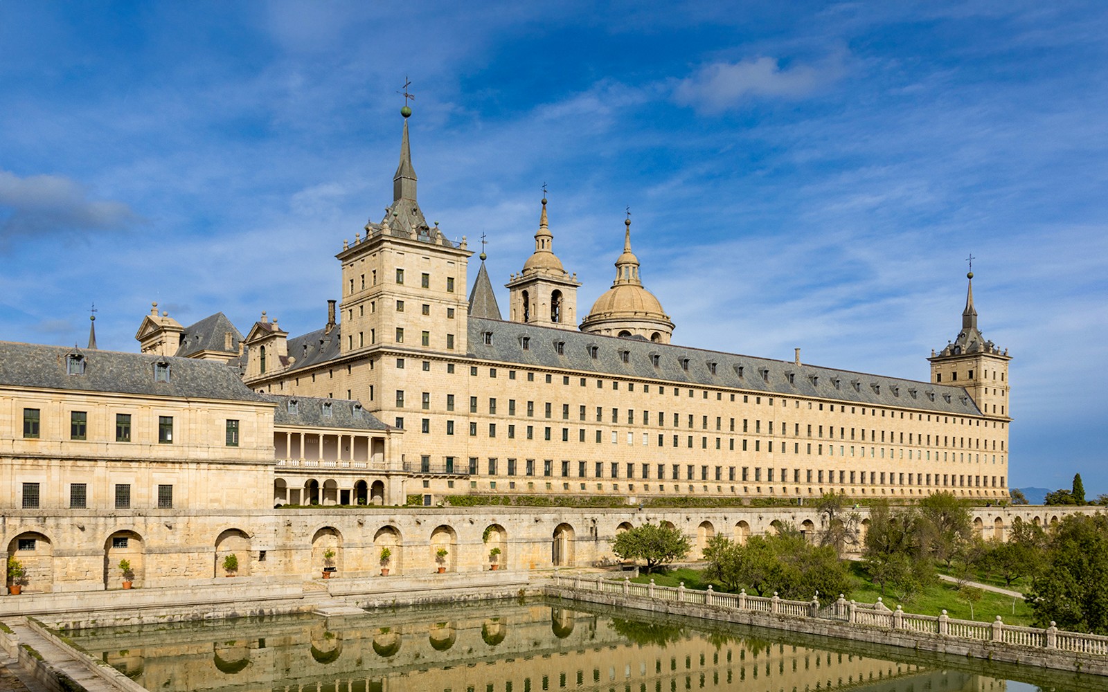 Klaustrið San Lorenzo de El Escorial með spegilmynd í tjörn, Spánn.