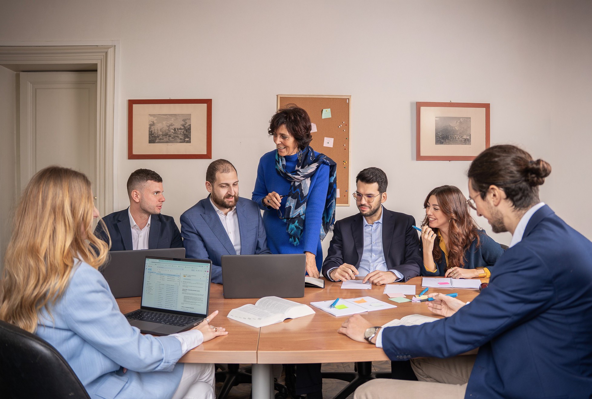 l team di CSA & Partners riunito in una sala riunioni luminosa, con consulenti uomini e donne che collaborano, sorridono e discutono progetti in un ambiente professionale e accogliente.