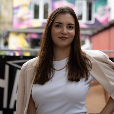 A person in a white shirt black coat with the fair skin looking infront