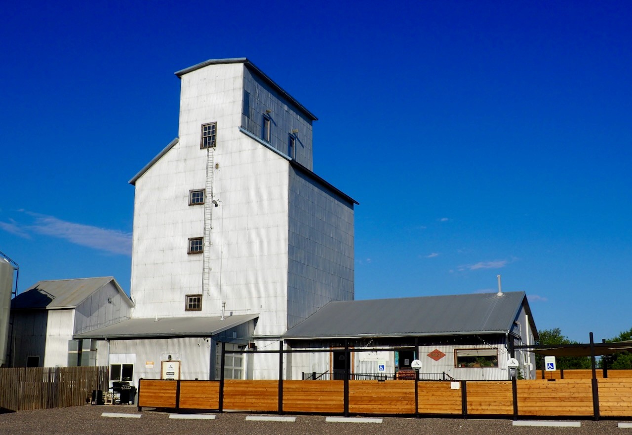 A white grain elevator against a blue sky in Wellington.