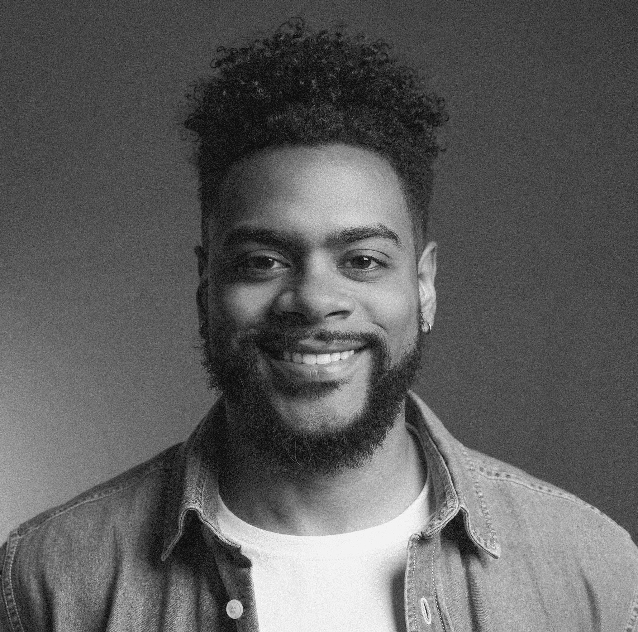 Portrait of a person in a pink sweater against a light background