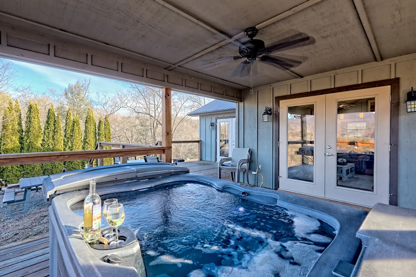 Eagles Nest covered deck with hot tub and French doors to the cabin