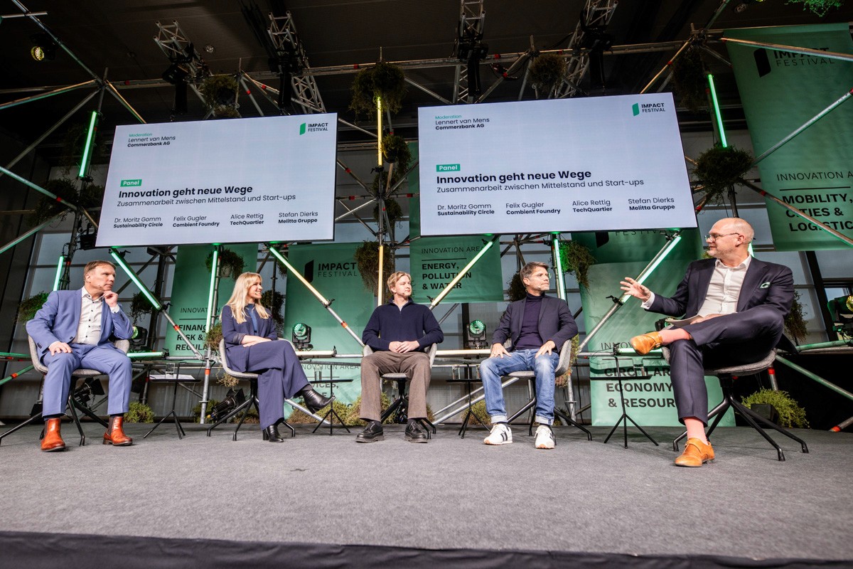 Zwei Geschäftsfrauen stehen an einem Messestand und unterhalten sich