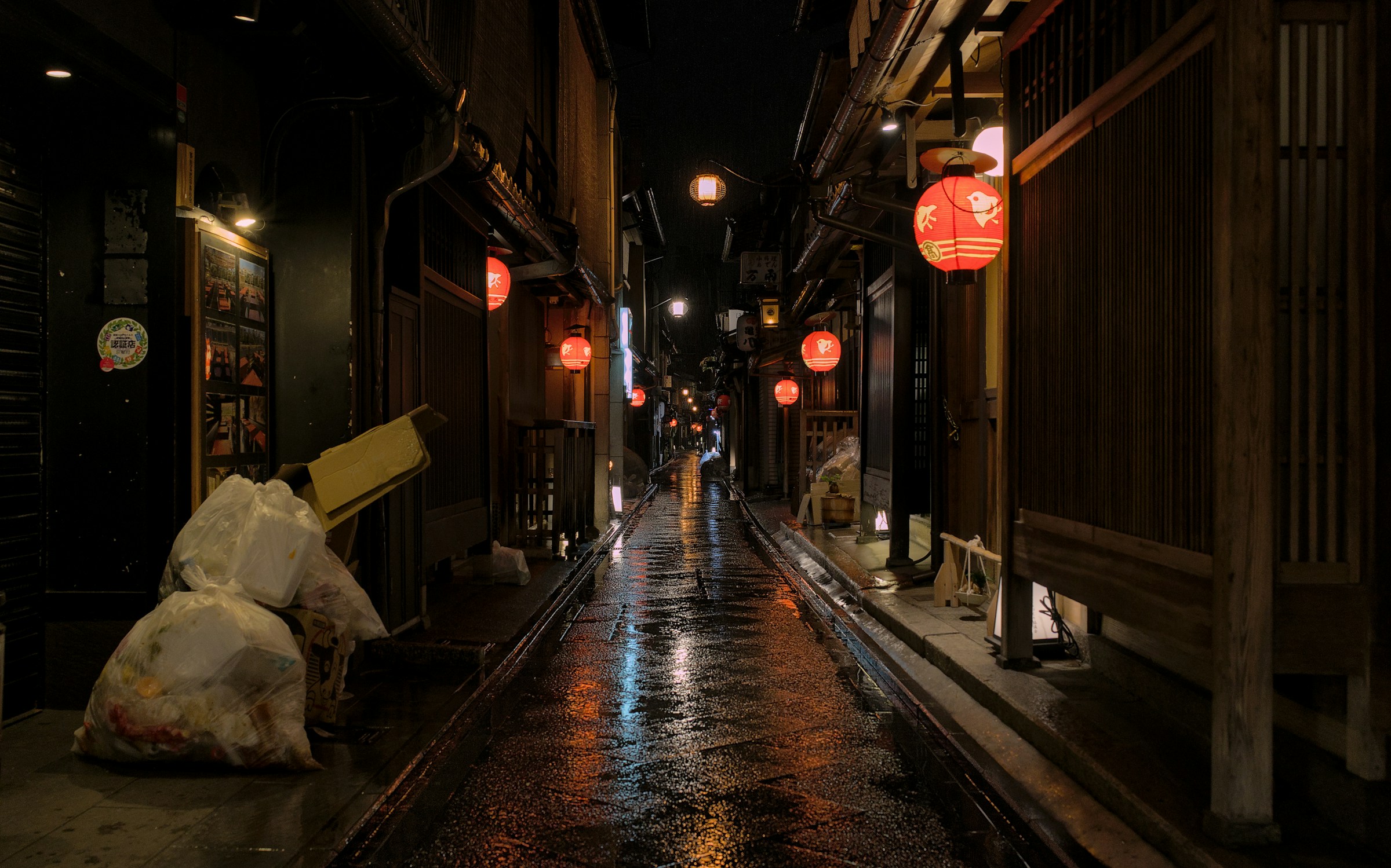 A narrow, lantern-lit alleyway at night
