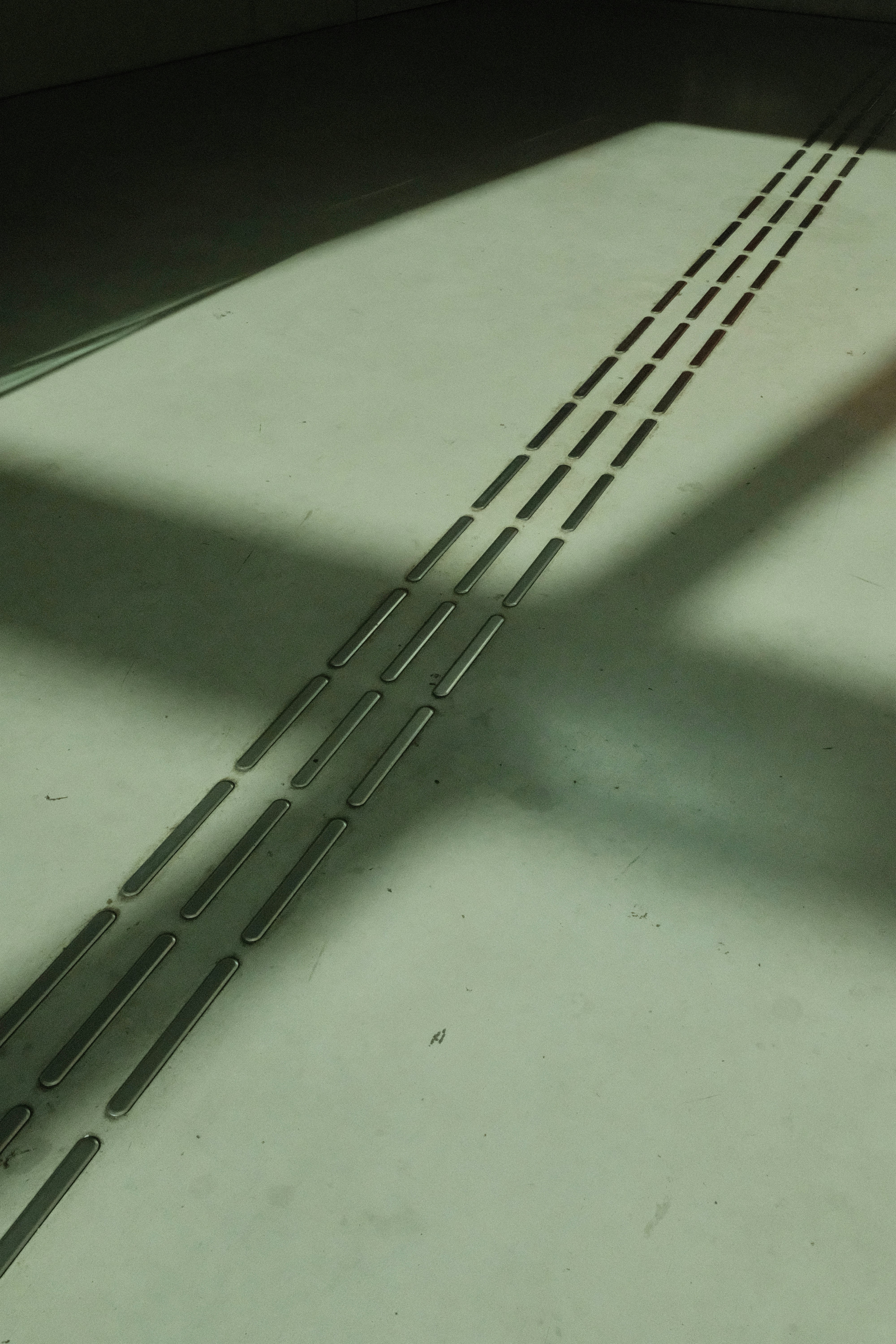 Tactile paving strips on a concrete floor.