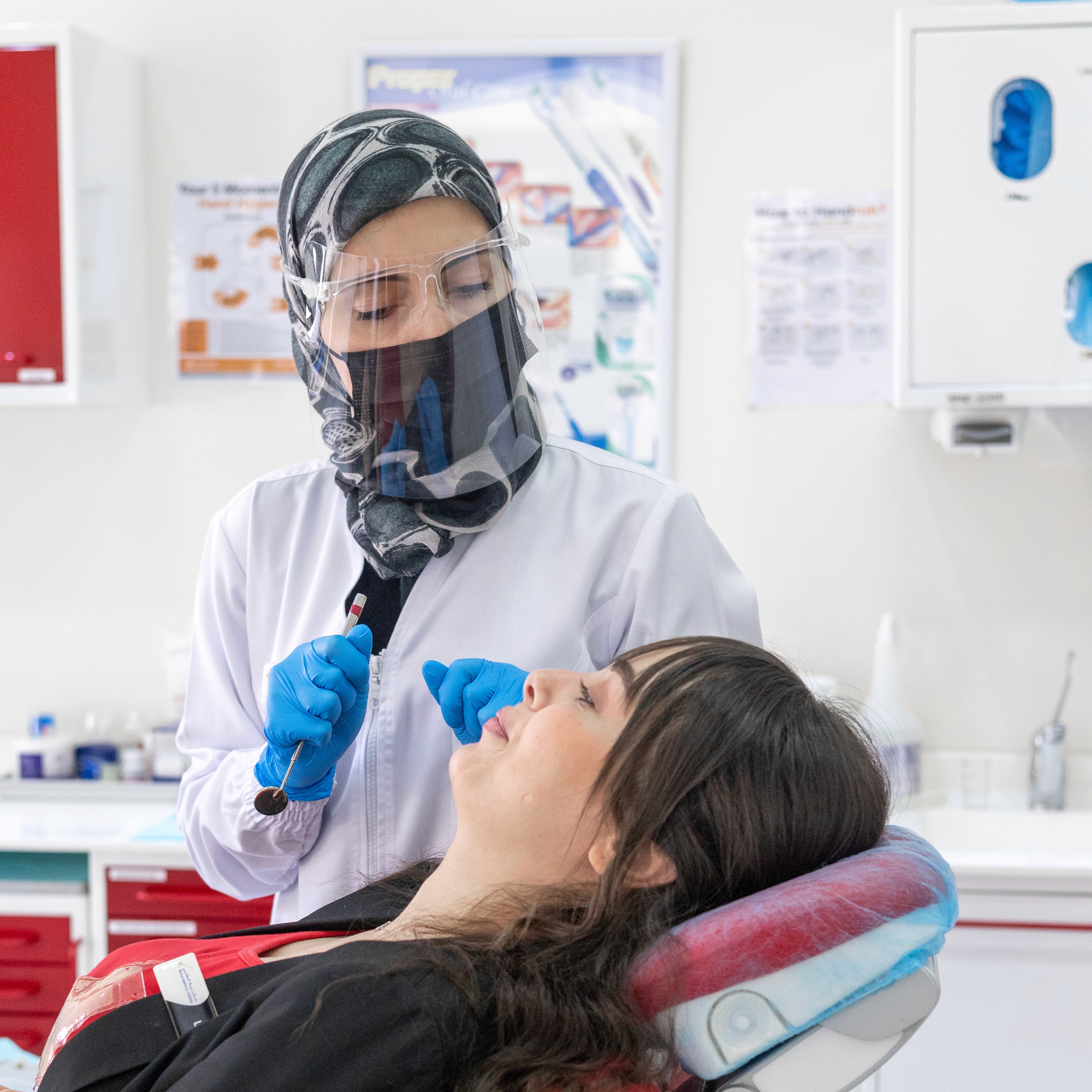 فتاة شقراء تبتسم وتعكس ابتسامة هوليود سمايل المثالية.