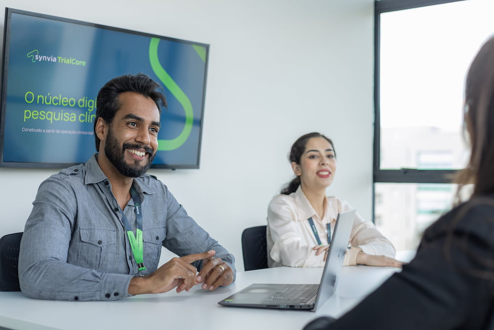 Equipe da Synvia conduzindo reunião estratégica de start-up para estudo clínico com análise de indicadores em dashboard
