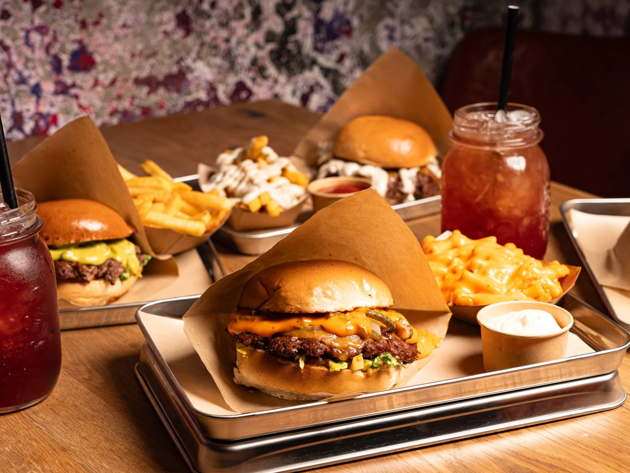A delicious assortment of burgers, fries, and drinks served on a tray in a casual dining setting.