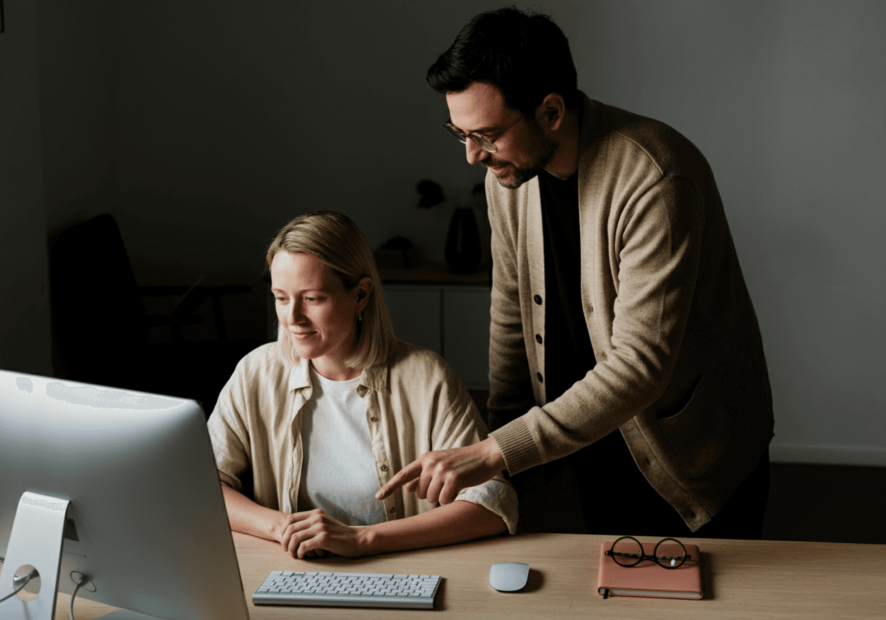 Two colleagues reviewing work on a screen together