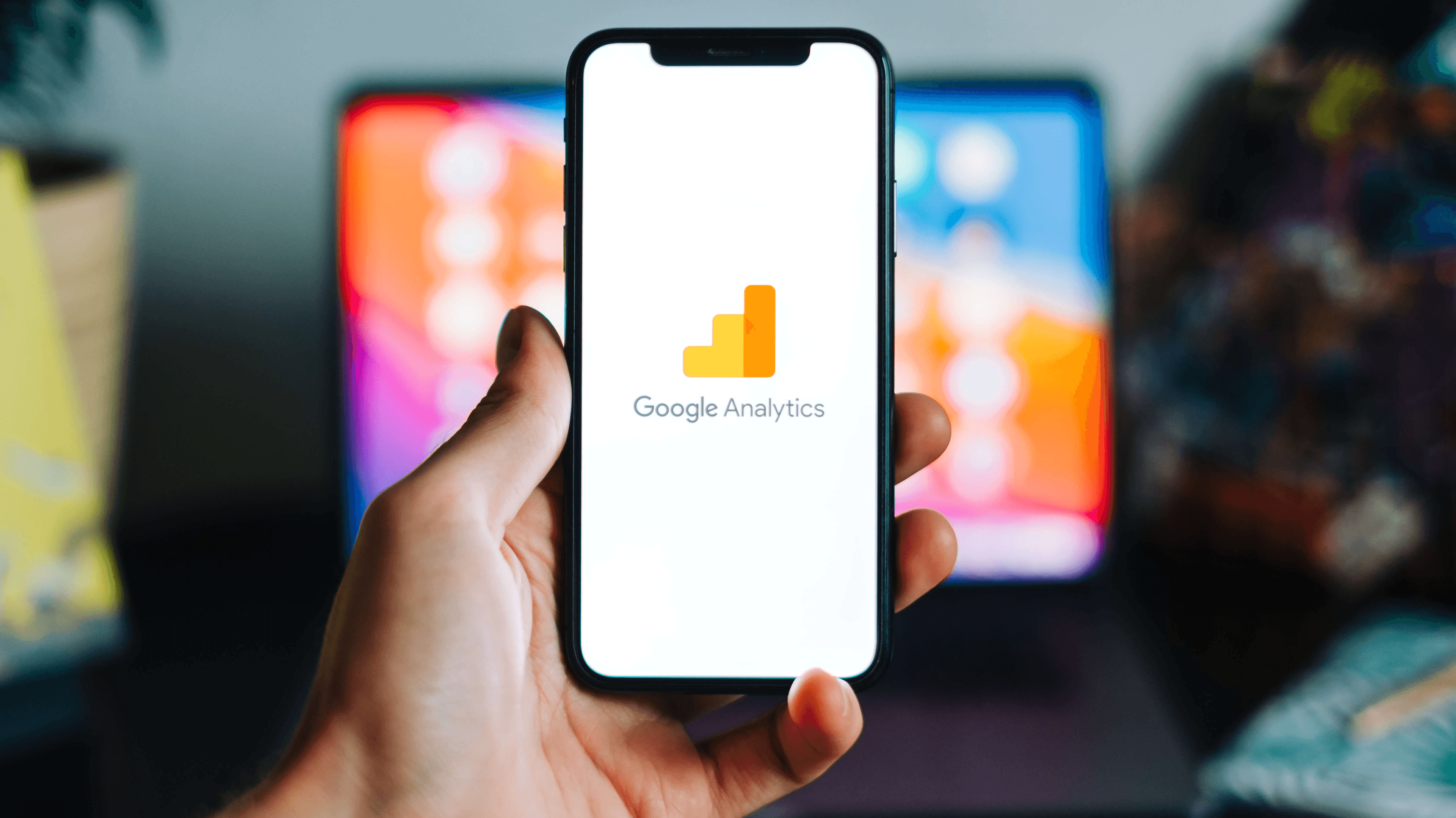 Hand holding up phone open to Google Analytics