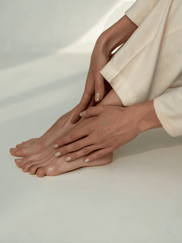 Feet of diverse participants on patterned mats on a wooden floor during a sunlit studio yoga session.