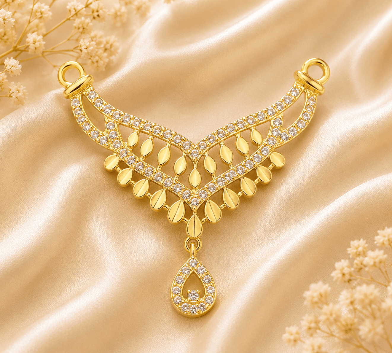 A gold necklace pendant with diamonds, set against a gold satin background with delicate flowers.