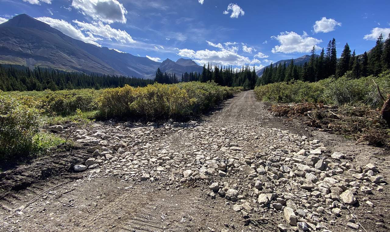 Refurbished multi-use trail with local cobble surface and Rocky Mountain valley backdrop at Cardinal River Headwaters