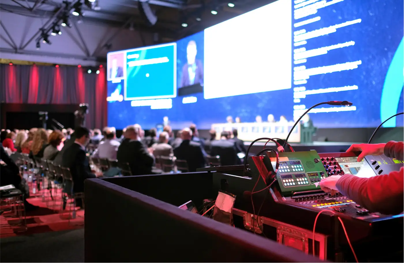 Un technicien travaille sur sa console son et lumière pendant une conférence événementielle d’entreprise.