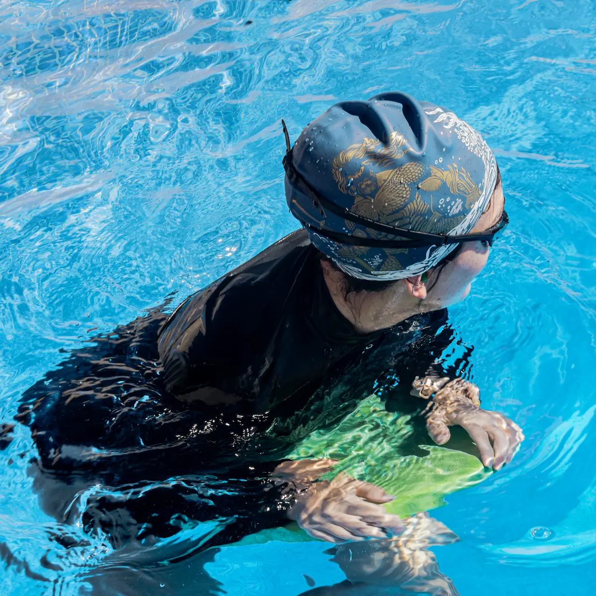 Mujer en una piscina con gorra de Poseídon de Poolvibes