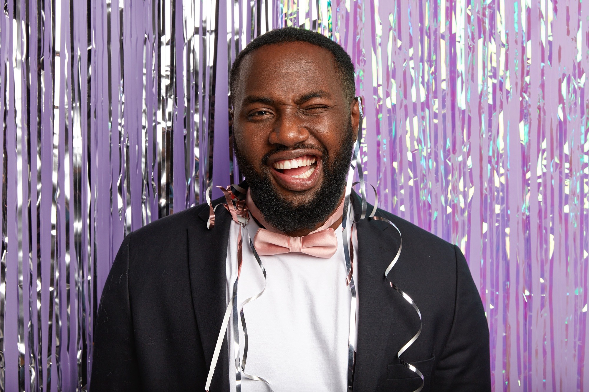 A happy person pictured at an event with a light purple background
