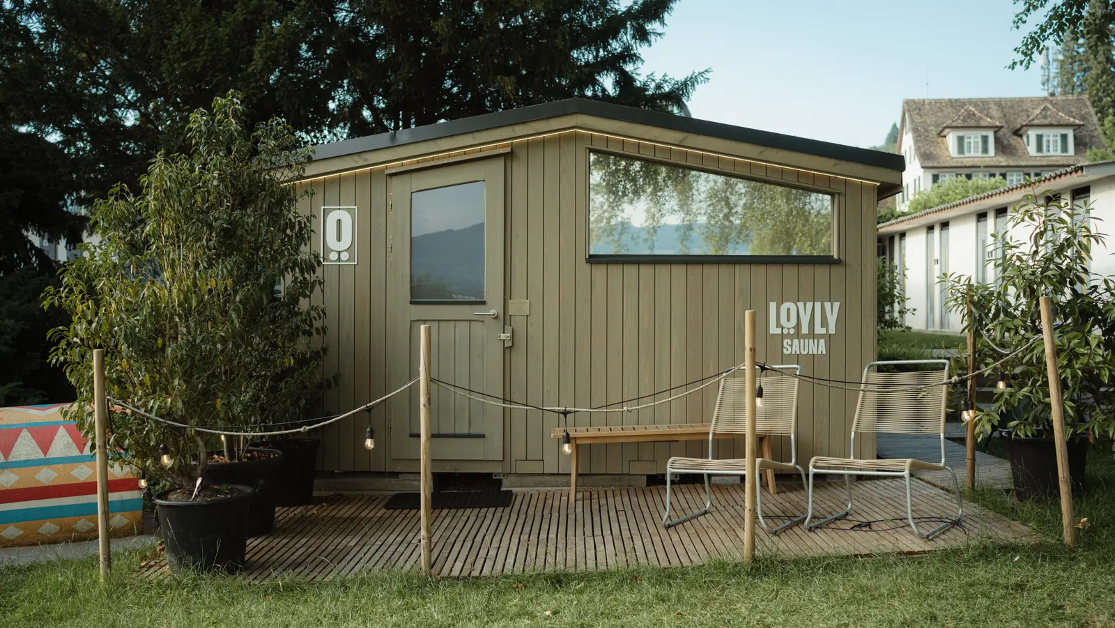 Mobile LÖYLY-Sauna im Strandbad Männedorf, eingebettet zwischen Bäumen und Natur für Sauna- und Wellness-Erlebnisse am Zürichsee.