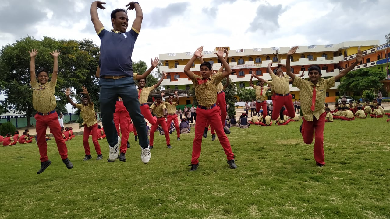 Three girls are sitting on a school bus and smiling.