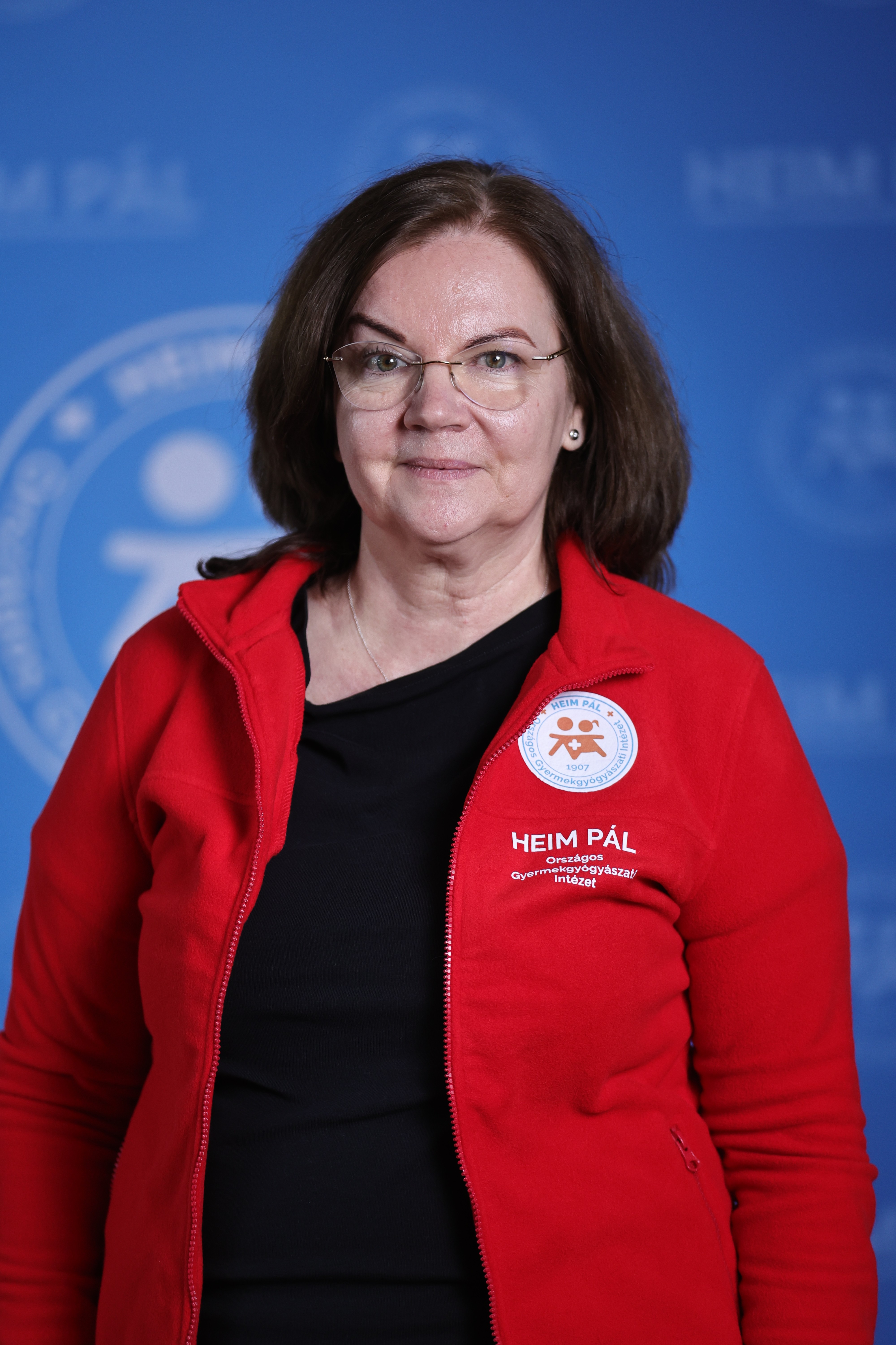 Szemüveges nő piros kardigánban