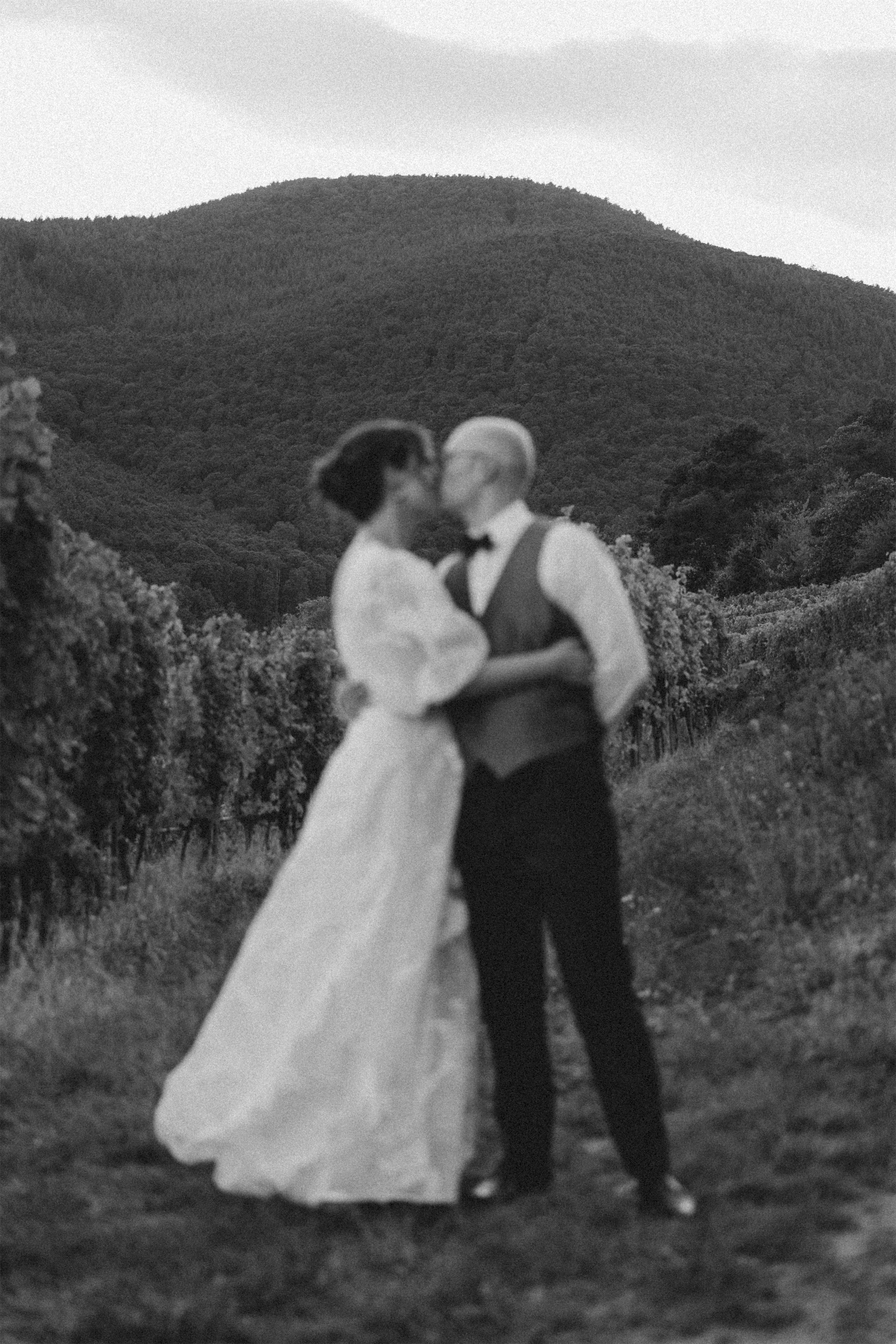 Cinematic black-and-white wedding photo of bride and groom while a wedding photoshoot