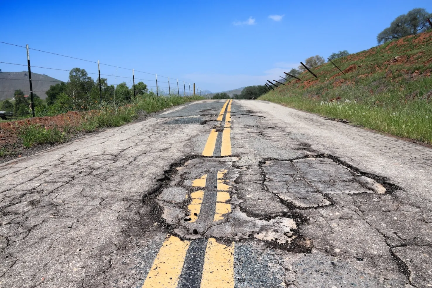 Cracked roadway caused by subgrade failure in clay soils after moisture exposure in the Kansas City area.