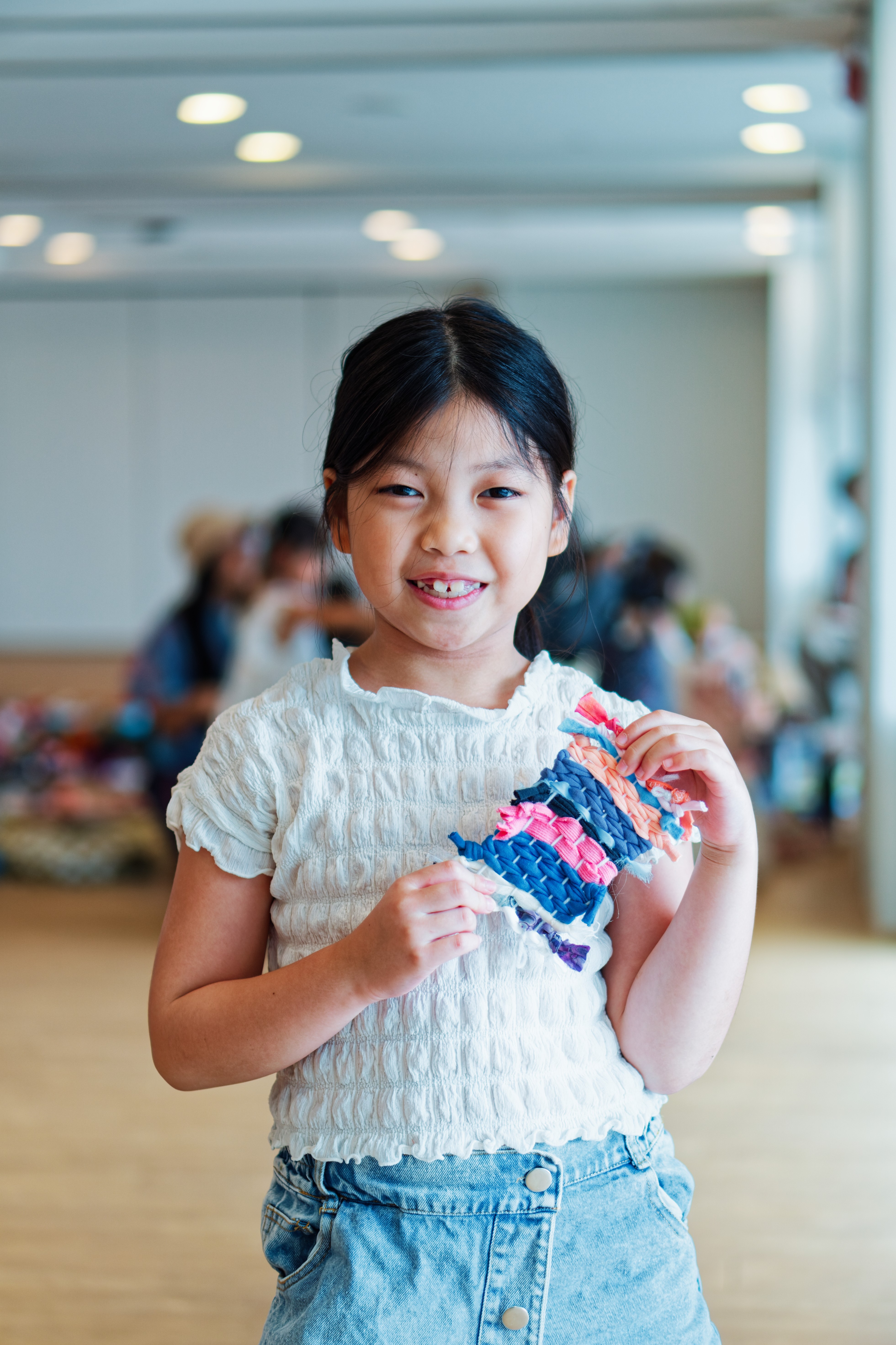 a young child holding a woven tapestry