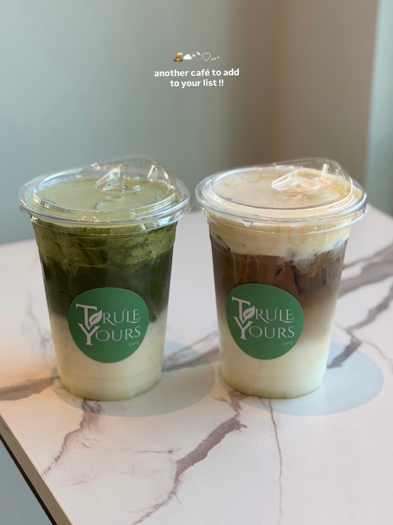 A matcha and coffee cup sitting in a cafe located in Seattle