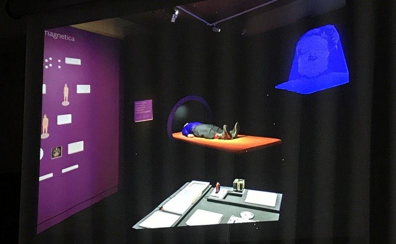 A photo of an exhibition showing images of bionic human and also a bionic body on a table.